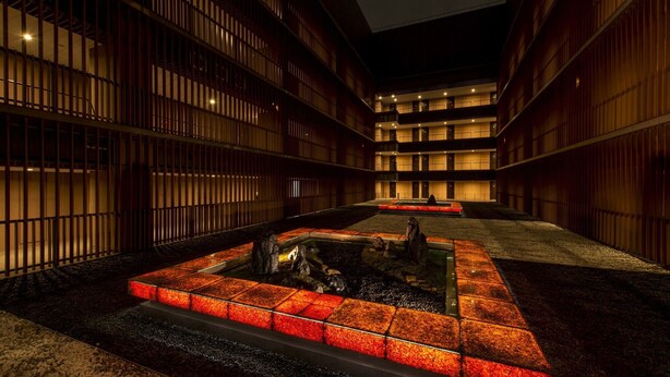 A courtyard with a water feature, surrounded by buildings with vertical wooden slats and multiple floors. - Hotel Villa Fontaine Grand Tokyo-Tamachi (Tokyo)