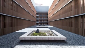 A modern building with a central courtyard featuring a water feature and seating. - Hotel Villa Fontaine Grand Tokyo-Tamachi (Tokyo)