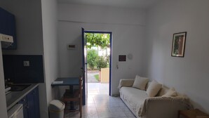 Un espacio habitable compacto con kitchenette, comedor y sofá.