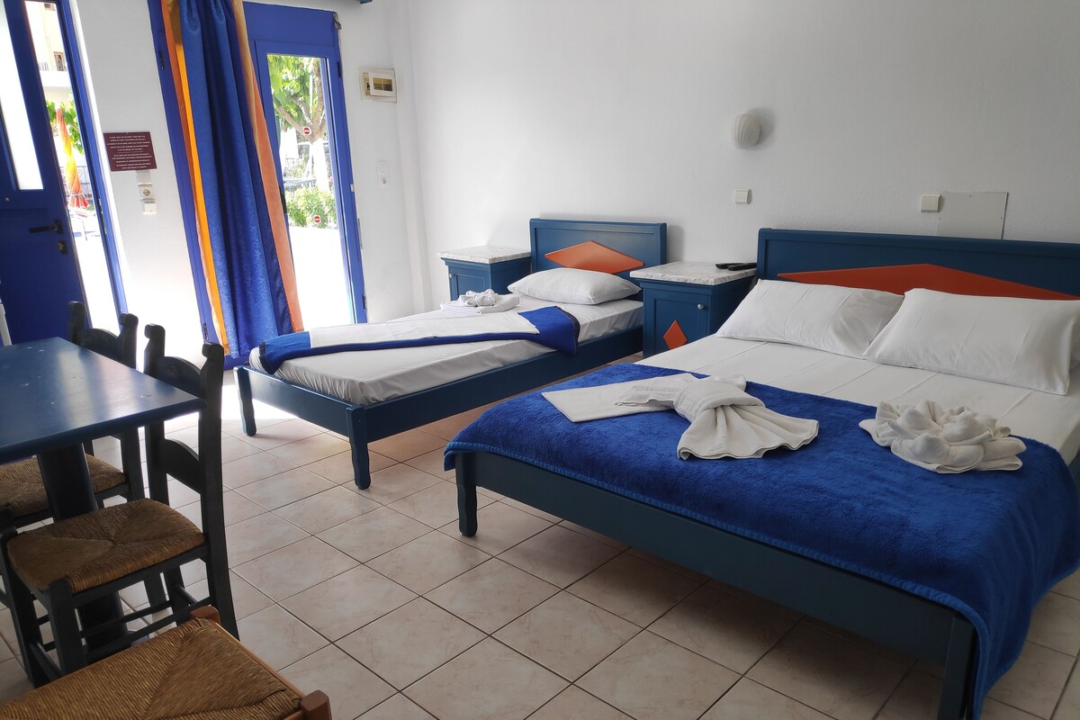 Una habitación de hotel con dos camas, una mesa de comedor y sillas.