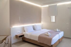 Ein modernes Hotelzimmer mit einem großen Bett, Nachttischen, einem kleinen Schreibtisch und einem Fenster.
