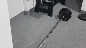 A gym with a barbell, dumbbells, and weight plates. - Ramira Beach Hotel (Alanya)