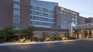 A modern Hyatt Place hotel with a glass facade, a covered entrance, and landscaped areas with lighting. - Hyatt Place Reno Tahoe Airport (Reno)