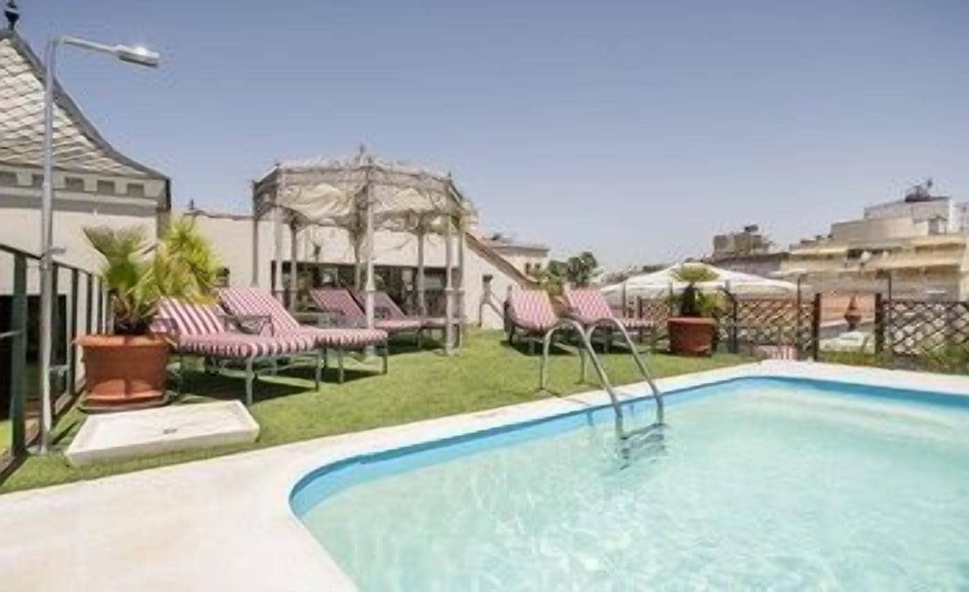 Una piscina con sillas de descanso y un pabellón.
