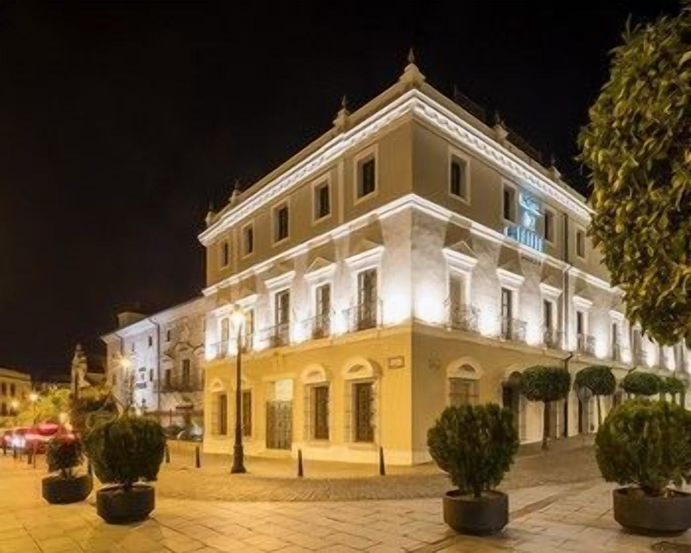 Un edificio con fachada simétrica, varias ventanas y una entrada central.