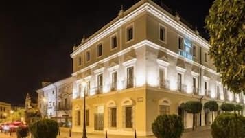 Un edificio con fachada simétrica, varias ventanas y una entrada central.