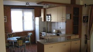 Cocina compacta con comedor, que incluye refrigerador, microondas y un lavamanos pequeño.