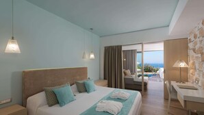 Habitación de hotel con cama, escritorio, silla y vista al mar.