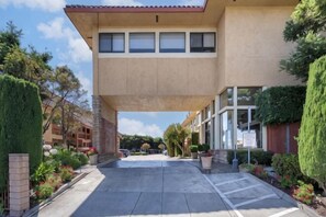 A building with a flat roof, large windows, and a paved entrance area with potted plants. - Best Western Plus Inn of Hayward (Hayward)
