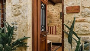 A stone building with a wooden door and a sign reading "AFRODIUM". - Casa Di Veneto (Hersonissos)
