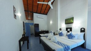 A bedroom with two beds, a ceiling fan, and a painting on the wall. - Dalawella Beach Resort (Unawatuna)