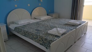 Ein Bett mit einem gemusterten Bettbezug, zwei Nachttische und ein Beistelltisch.