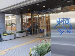 De ingang van Toyako Inn met een modern ontwerp, met een glazen deur en borden in zowel Engels als Japans.