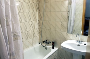 Un baño con bañera, lavamanos y ducha.