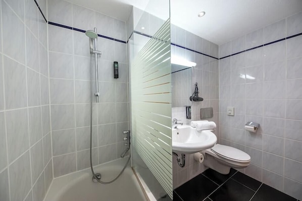 A bathroom with a shower, toilet, and sink. - Achat Hotel Frankfurt Maintal (Maintal)
