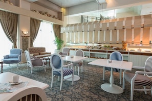 A hotel lobby with striped chairs, a sofa, a dining area, and a buffet. - Herods Vitalis Spa Hotel Eilat (Eilat)