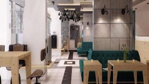 Un intérieur moderne comprenant un coin repas, un canapé et un mur orné d’un motif géométrique.