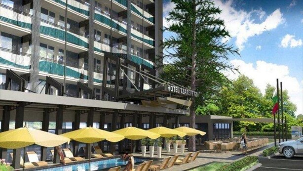 Un hôtel doté d’une piscine, d’un espace extérieur aménagé et d’une zone couverte avec des parasols.