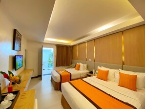 A hotel room with two beds, a desk with a fruit bowl, and a TV on the wall. - Jonys Beach Resort (Boracay Island)