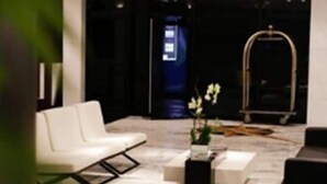 A modern lobby with a white sofa, a coffee table, and a decorative archway. - Royal Savassi Boutique Hotel (Belo Horizonte)