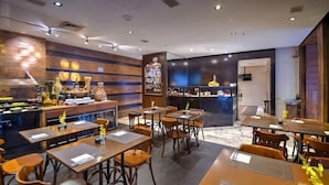 A restaurant with wooden decor, tables, chairs, and a counter. - Royal Savassi Boutique Hotel (Belo Horizonte)