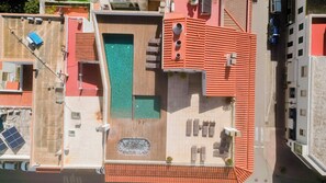 A rooftop with a swimming pool, a covered seating area, and a solar panel array. - Loar Ferreries (Ferreries)