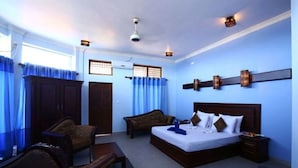 Una habitación de hotel con una cama grande, un escritorio, una silla y un armario.