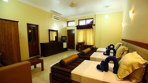 Una habitación de hotel con sofá, cama, escritorio y televisión.