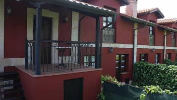 Un edificio rojo con balcón y terraza cubierta.