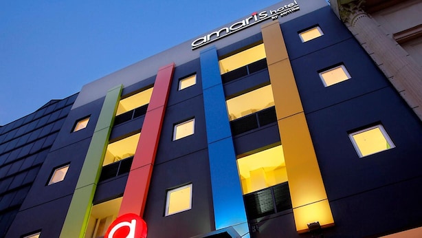 Een modern hotelgebouw met een opvallend 'Maris Hotel' bord.