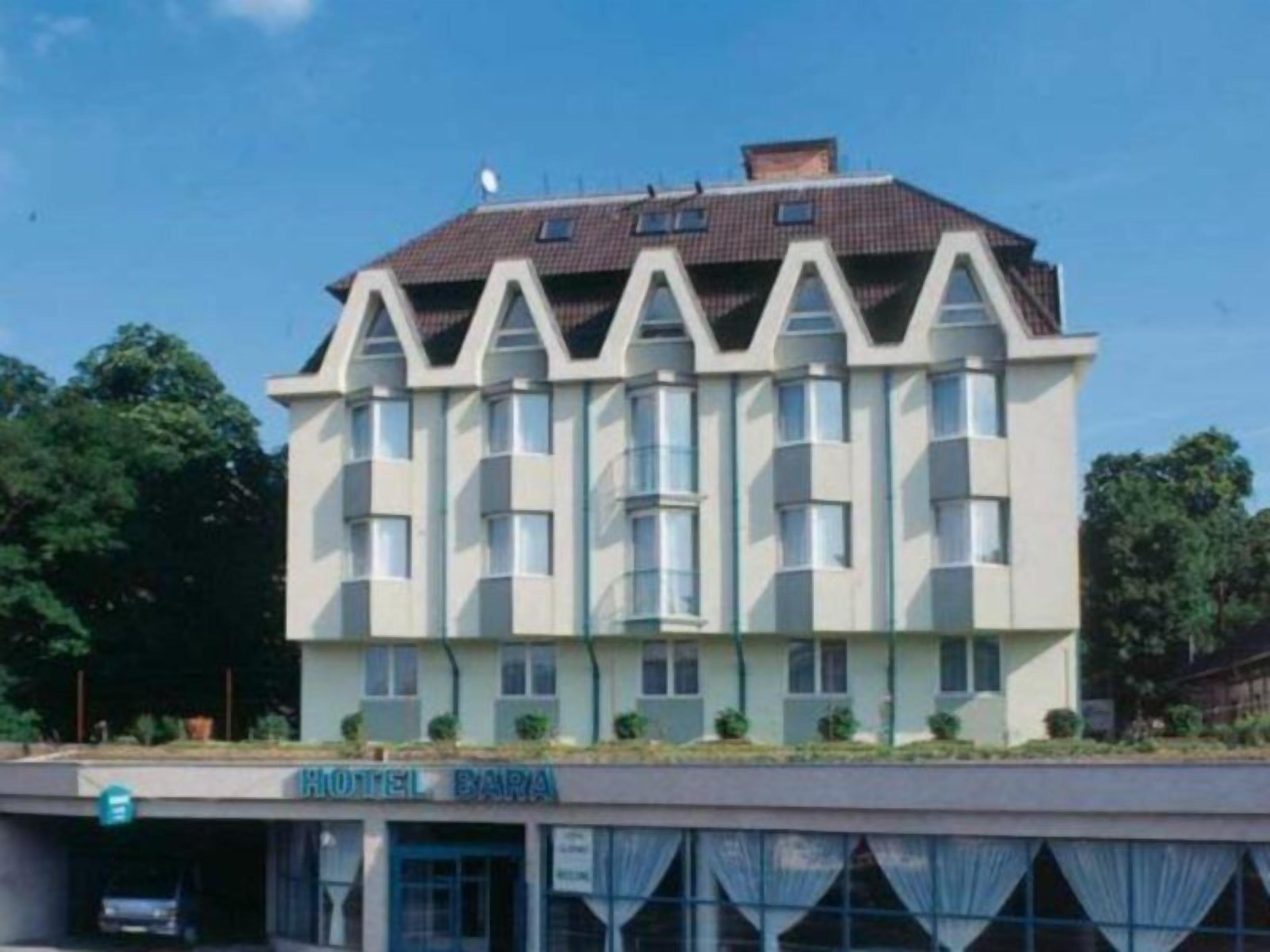 Un hotel de varios pisos con techo plano y un cartel que dice 'HOTEL BARNA'.