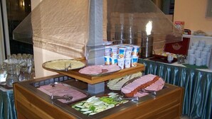 A buffet setup with various food items and beverages. - Bara (Budapest)
