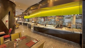 Un restaurant d’hôtel moderne, doté d’un buffet, d’un sol en marbre et de mobilier contemporain.