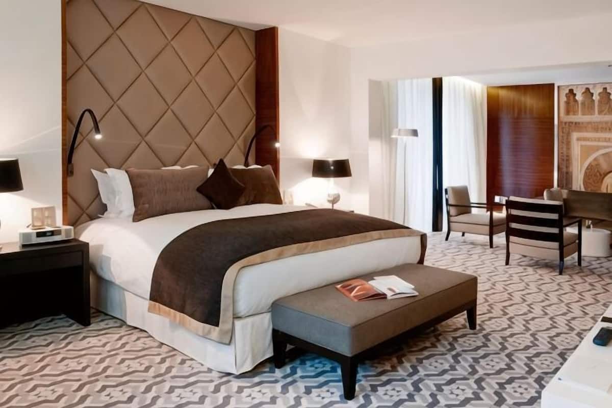 Une chambre d’hôtel moderne avec un grand lit, des tables de chevet, un bureau et une chaise.