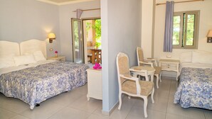 A hotel room with two beds, a small desk, a chair, and a window with curtains. - Efrosini Village (Kefalonia)