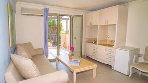 A living room with a sofa, a coffee table, a cabinet, and a chair. - Efrosini Village (Kefalonia)