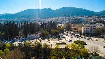 Un paisaje urbano con una glorieta destacada, edificios y montañas al fondo.