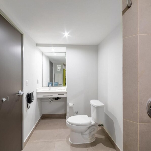 Un baño pequeño y moderno con inodoro, lavabo y espejo.