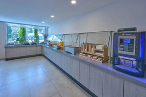 En moderne café med en selvbetjeningskaffemaskine, en glasvæg og udsigt til gaden.