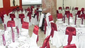 A conference room with tables set for an event, red and white tablecloths, and a projector screen displaying text. - Hotel Isla de Sacrificio (Veracruz)