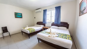 A hotel room with two beds, a chair, and a window with curtains. - Hotel Isla de Sacrificio (Veracruz)
