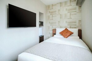 Ein Hotelzimmer mit einem Bett, einem flachbildfernseher an der Wand und einer Wand mit Muster.