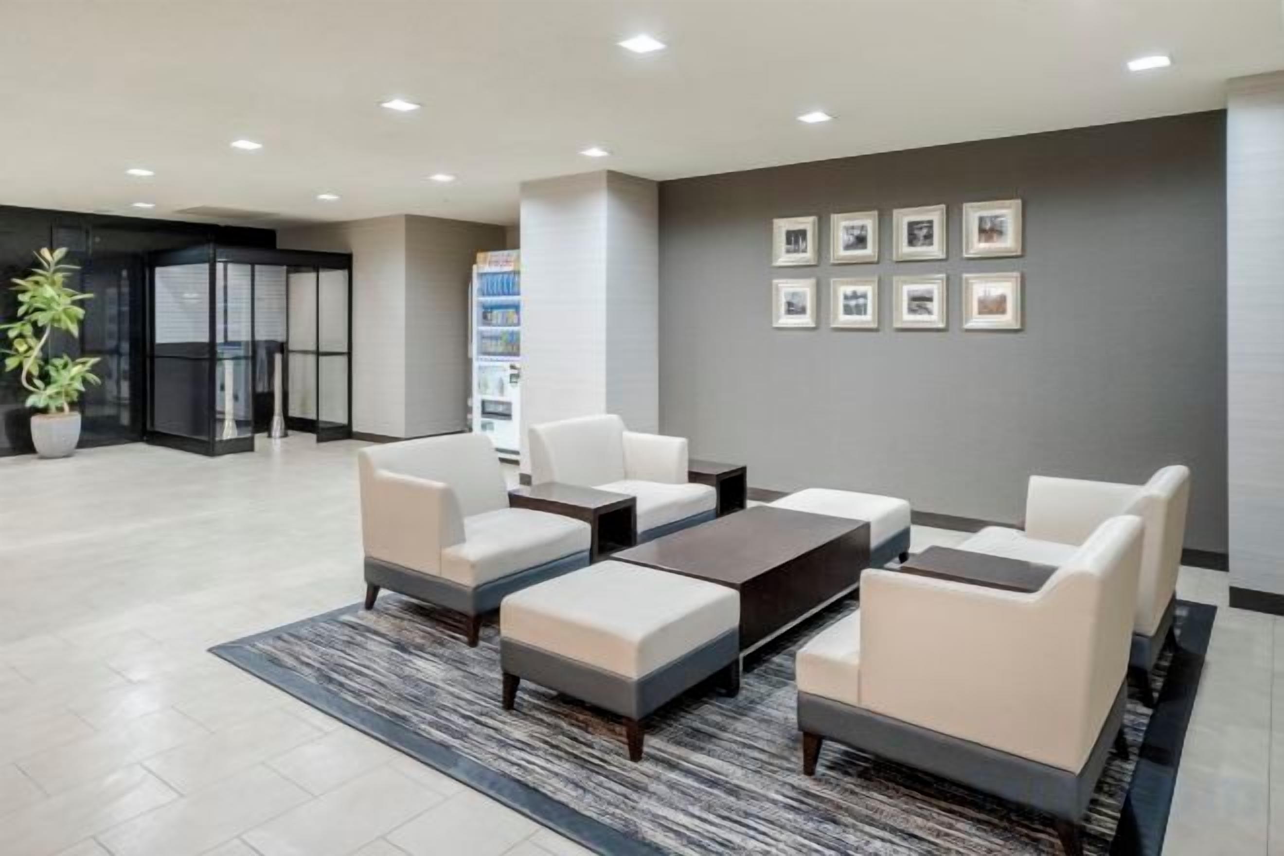 A modern lobby with a seating area, a reception desk, and framed pictures on the wall.