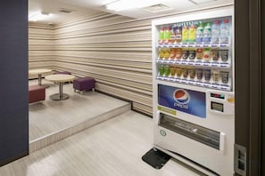 A vending machine with various beverages and a Pepsi logo, located in a room with striped walls and a small table and chair. - HOTEL MYSTAYS Nagoya Sakae　Renewed in September 2026 – All Guest Rooms & Breakfast (NAGOYA)