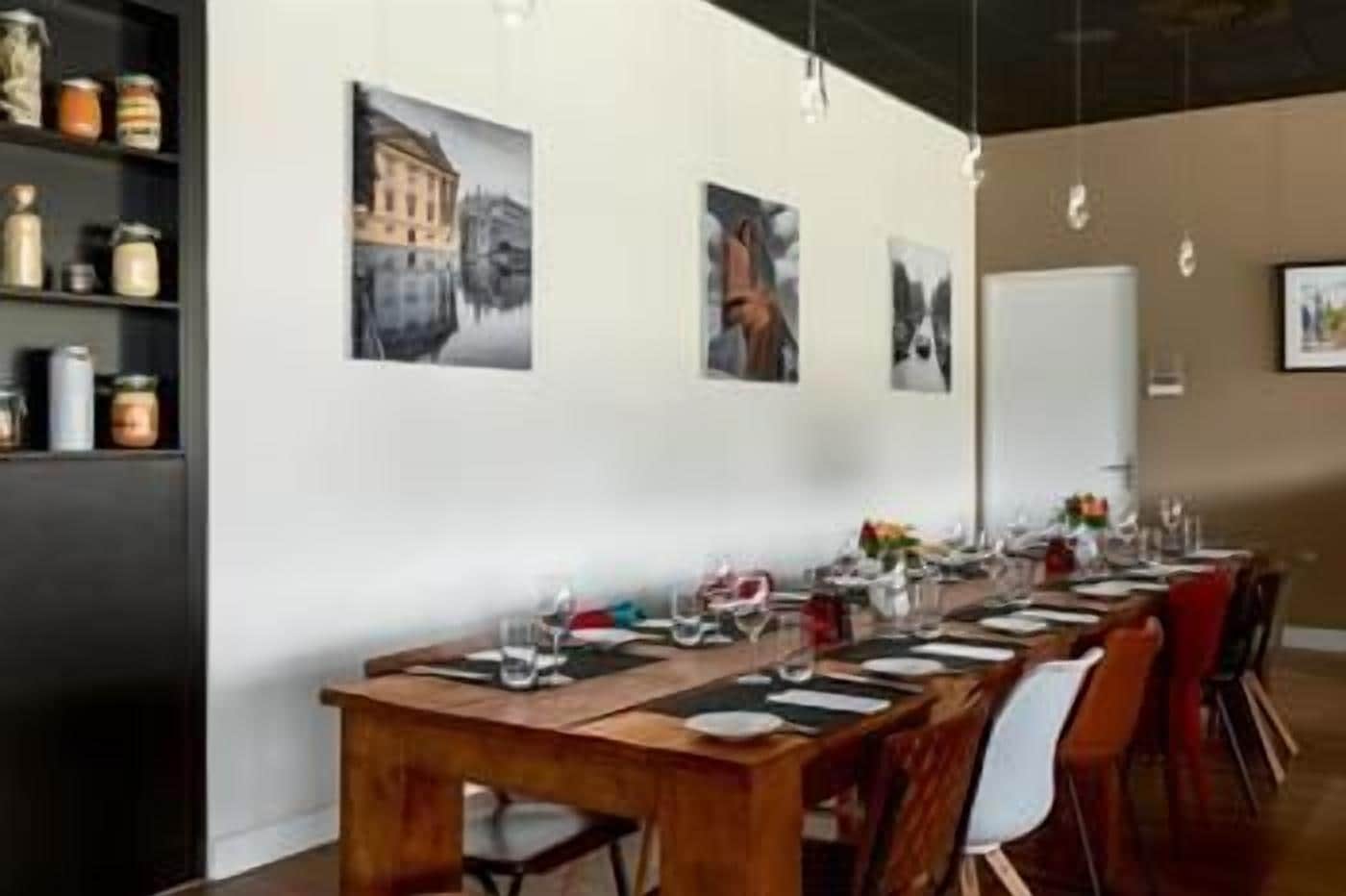 A dining area with a long wooden table set for a meal, surrounded by chairs.
