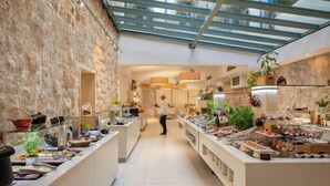 Ein modernes Frühstücksbuffet mit Glasdecke, Steinwänden und verschiedenen Speisebereichen.