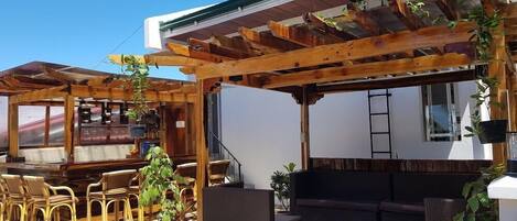 An outdoor patio area with wooden furniture and potted plants.