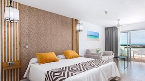 Une chambre d’hôtel moderne avec un grand lit, un canapé, un balcon avec vue et un mur à texture.