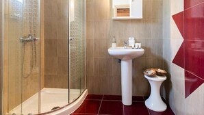 A modern bathroom with a glass-enclosed shower, a pedestal sink, and a toilet. - Stergios Villa (Rhodes)