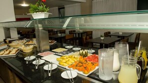 A buffet with various food items and beverages, including fruits, vegetables, and drinks. - Stop Inn Plus Pampulha (Belo Horizonte)